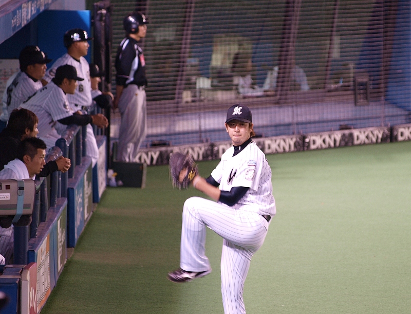 Lotte starter Ohmine warms up on the sideline