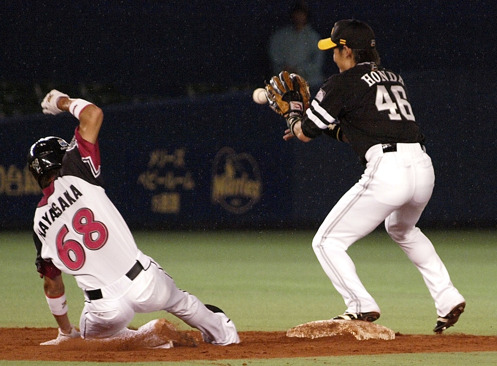 909_hayasaka As the rain falls, Hayasaka slides in to second in a very close play